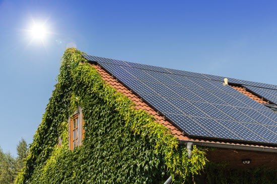 Efeu-bewachsenes Haus mit Solaranlage auf dem Dach