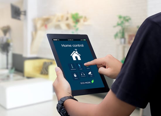 Person regelt den Energieverbrauch im Smart Home mit dem Tablet