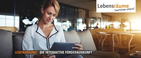 Frau sitzt auf dem Sofa mit einem Tablet in den Händen