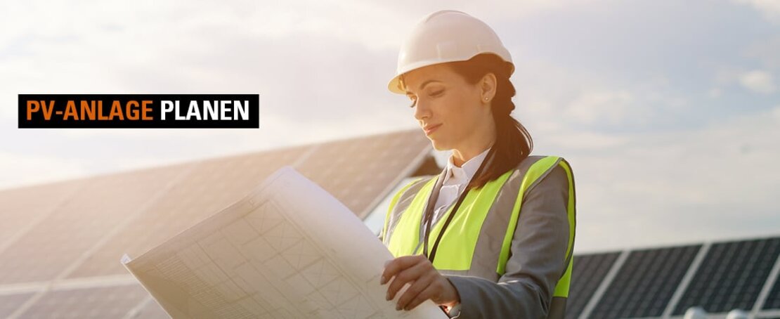 Eine Bauingenieurin steht vor einer PV-Anlage und überprüft die Baupläne.