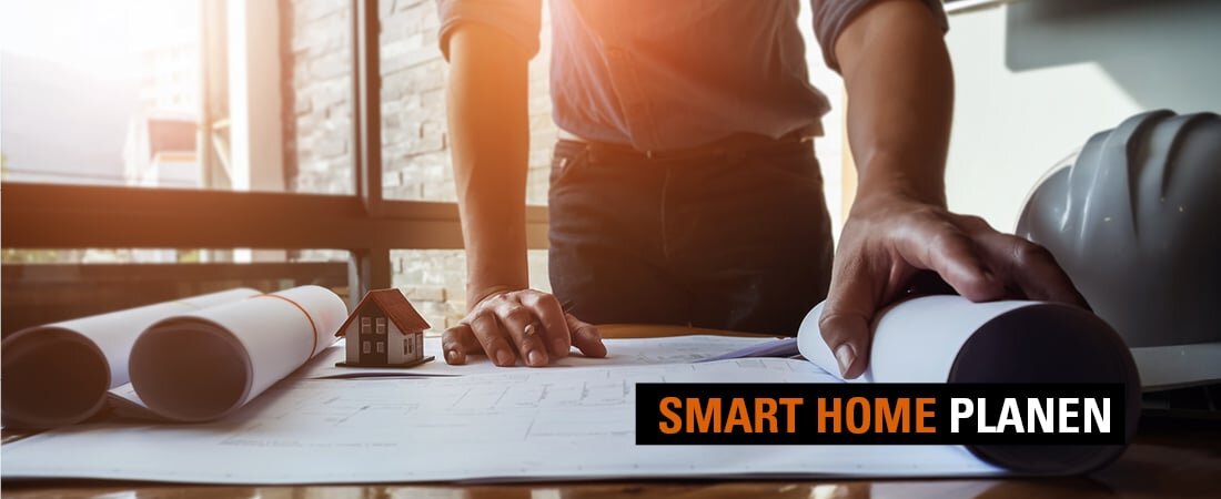 Ein Smart Home-Planer breitet Planungsunterlagen auf einem Tisch aus.