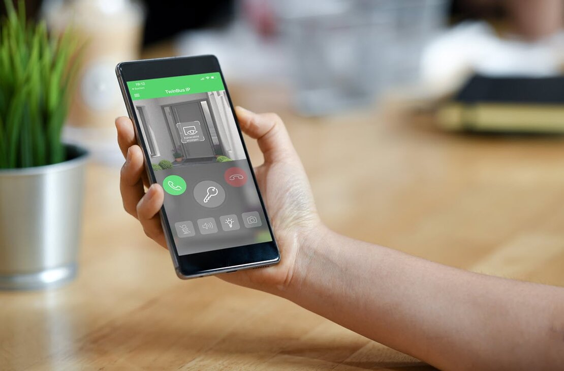Eine Hand hält ein Smartphone mit der geöffneten Ritto TwinBus IP-App.