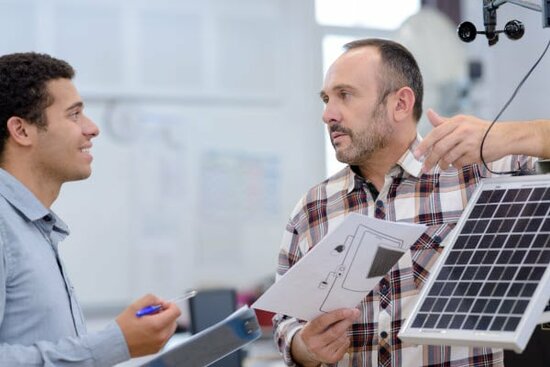Ein PV-Experte berät einen Mann in einem Verkaufsraum mit Solarmodul. | © 2019 ALPA PROD/Shutterstock.