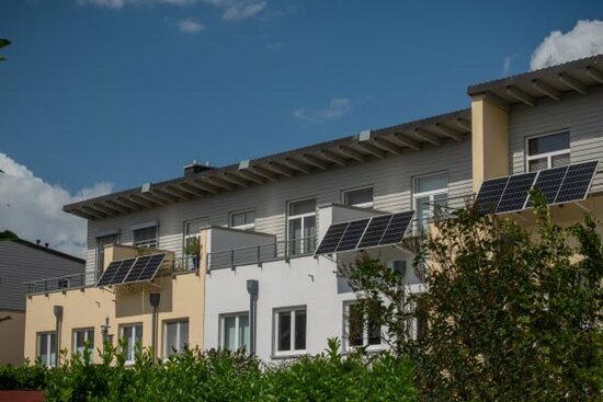  Mehrfamilienhäuser mit Solarmodulen am Balkon im Sommer. | © 2023 Snapshot freddy/Shutterstock