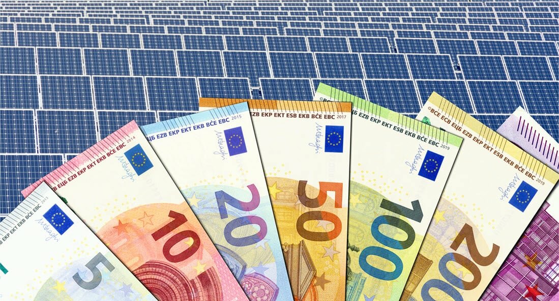 Abbildung von Euro-Geldscheinen vor Solarmodulen | © 2021 DesignRage/Shutterstock.  No use without permission.