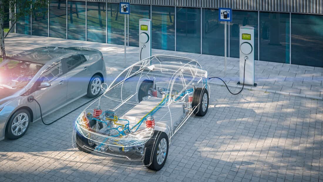 E-Auto mit durchsichtiger Karosserie lädt an öffentlicher Ladesäule auf einem Parkplatz. | © 2020 Herr Loeffler/Shutterstock.