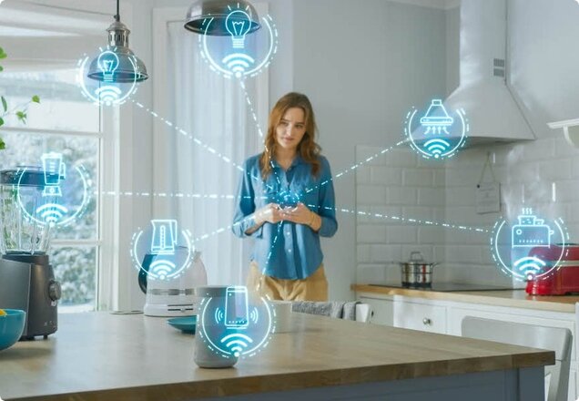 Eine Frau steht in der Küche und steuert das Smart Home mit Ihrem Handy | © 2020 Gorodenkoff/Shutterstock.  No use without permission.